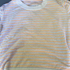 These shirt is from madewell and it’s colors are a peach, orange, and blue.